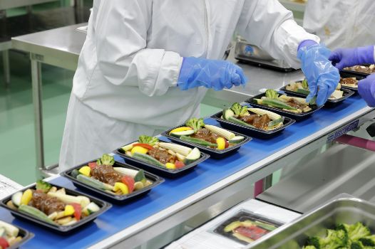 弁当に食材を詰めている写真